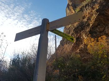 Low angle view of road sign against sky