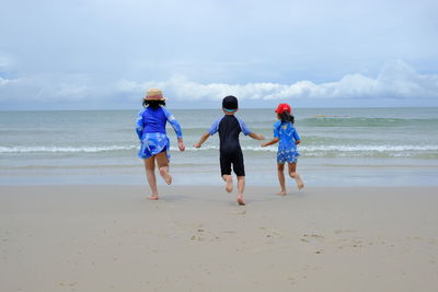 Happy children playing water on beach