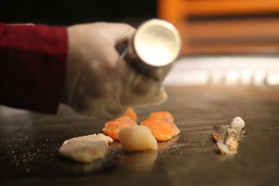 Cropped hand of  a person preparing food on a table