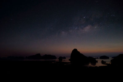 Scenic view of silhouette rocks against sky at night