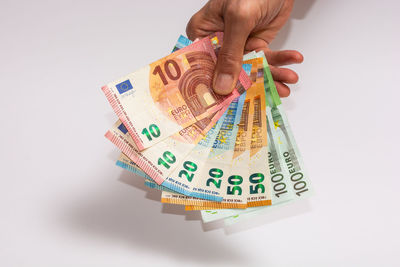 Midsection of person holding paper against white background