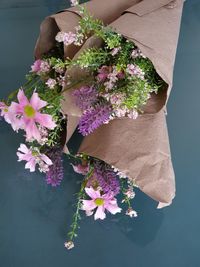 High angle view of woman holding pink flowering plant