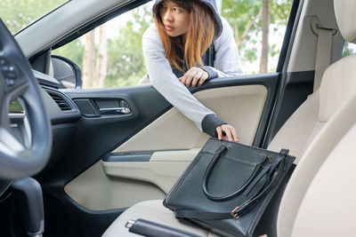 Full length of woman sitting in car