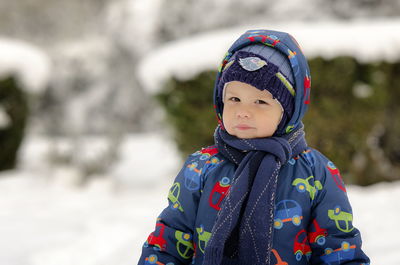 Portrait of cute boy looking away during winter