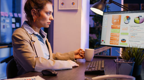 Young woman using mobile phone in office