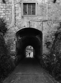 Rear view of man walking in old tunnel