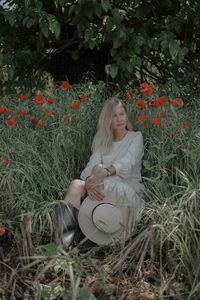 Portrait of young woman sitting on field