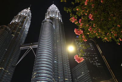 Low angle view of illuminated buildings against sky at night