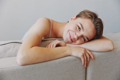 Young woman sitting on sofa at home