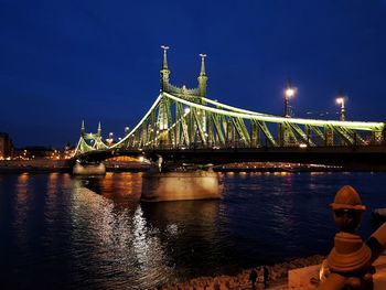 Illuminated suspension bridge over river at night