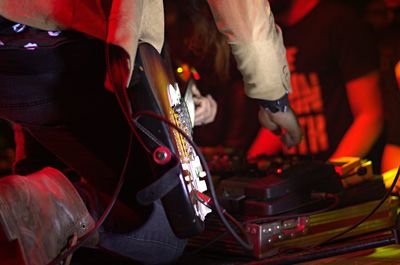 Low section of male guitarist with musical equipment of stage