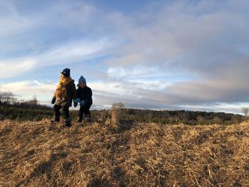 Two boys at sunset in a sunny field