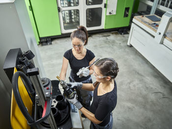 Two women working on a machine