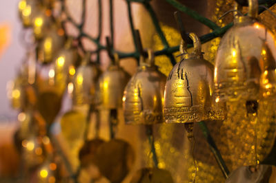 Close-up of illuminated lighting equipment hanging in temple