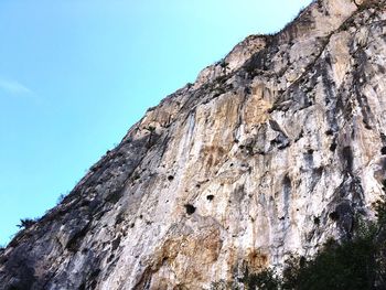 Low angle view of rock formation against clear blue sky