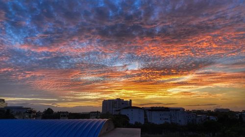 Buildings against dramatic sky during sunset