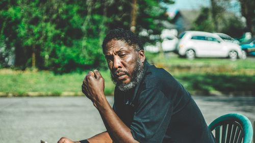 Man looking away while sitting on road