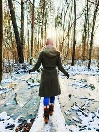 Rear view of woman standing on snow covered land