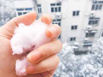 Close-up of cropped hand holding snow