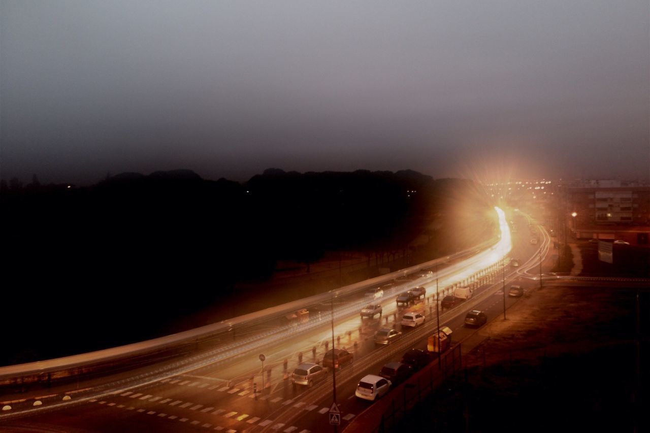 illuminated, transportation, night, long exposure, light trail, mode of transport, high angle view, motion, speed, road, city, land vehicle, car, on the move, traffic, sky, street, blurred motion, built structure, architecture