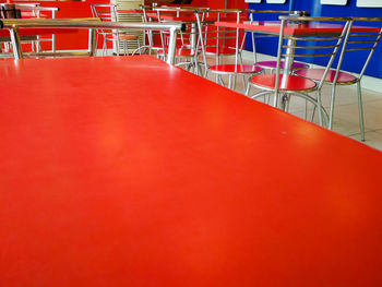Empty chairs and table by swimming pool