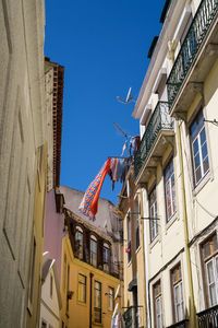 Laundry hanging from a balcony in a lisbon alley