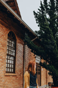 Low angle view of woman against building