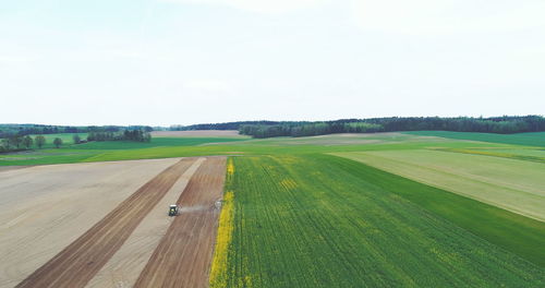 Road amidst field against sky