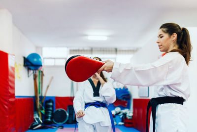 Young woman with instructor practicing martial arts