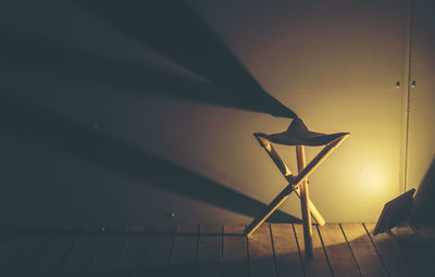 Low angle view of illuminated lamp on wall