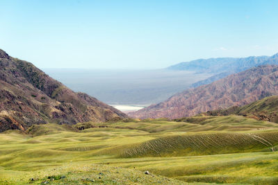 Scenic view of landscape and mountains against clear sky