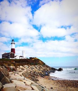 Low angle view of lighthouse by sea against cloudy sky at montauk point state park