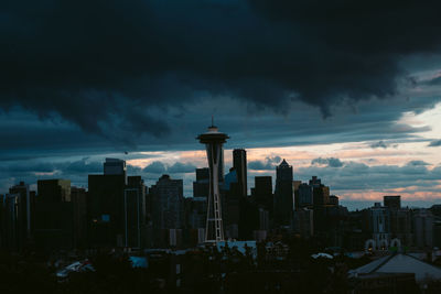 Buildings in city against cloudy sky