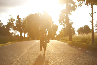 Mid adult cyclist standing on road, sweden