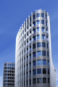 Low angle view of modern building against clear blue sky