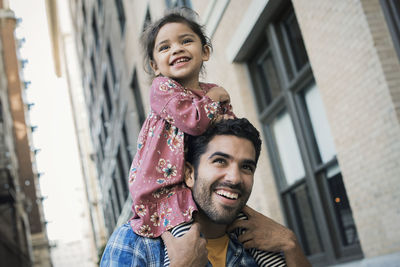 Father carrying daughter on his shoulders