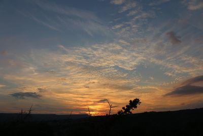 Scenic view of silhouette field against sky at sunset