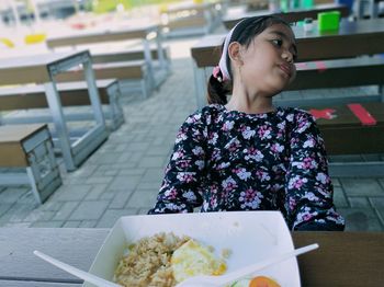 Portrait of young woman sitting at restaurant table