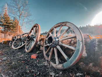 Abandoned wheel on field against sky