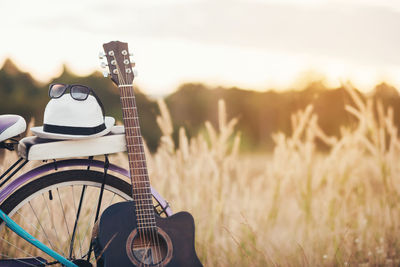 Close-up of guitar on field against sky