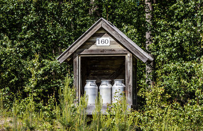 Canisters in wooden structure against trees