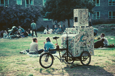 People sitting on bicycle parked against building