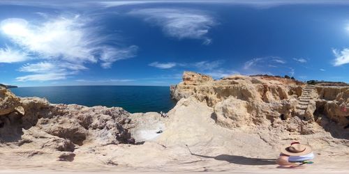 Rock formations on beach against sky