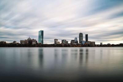 River by buildings against sky in city