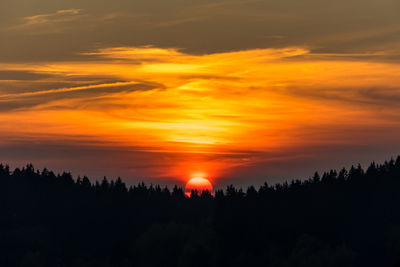 Scenic view of silhouette landscape against orange sky