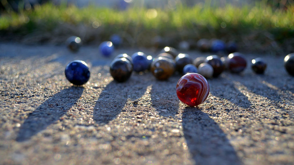 selective focus, close-up, focus on foreground, surface level, metal, day, no people, field, outdoors, nature, in a row, grass, wood - material, sunlight, textured, still life, tranquility, road, metallic, street