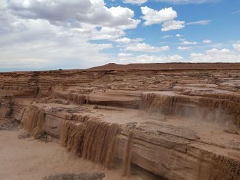 View of desert against cloudy sky