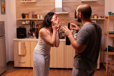 Side view of young woman drinking milk at home