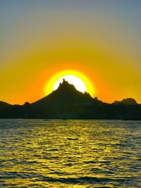 Scenic view of sea against orange sky