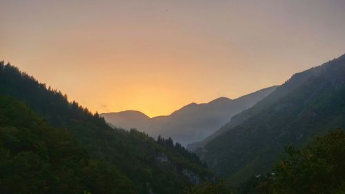 Scenic view of silhouette mountains against sky during sunset